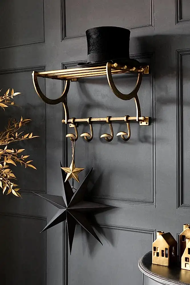 Lifestyle image of the Antique Gold Luggage Rack With Coat Hooks