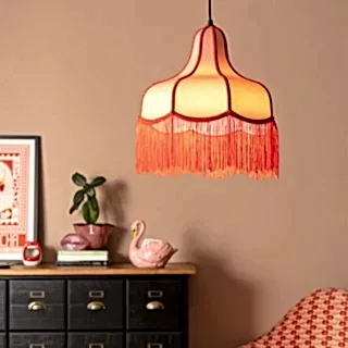A gold cherub ceiling light styled above some accessories.