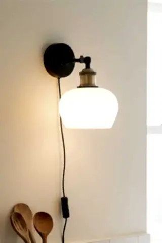 Image of the Beautiful Glass Plug In Wall Light switched on in a bright kitchen.