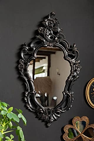 The Beautiful Ornate Black Wall Mirror shown on a black wall. 