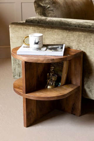The Dark Wood Shelf Side Table shown against a green velvet sofa in a living room