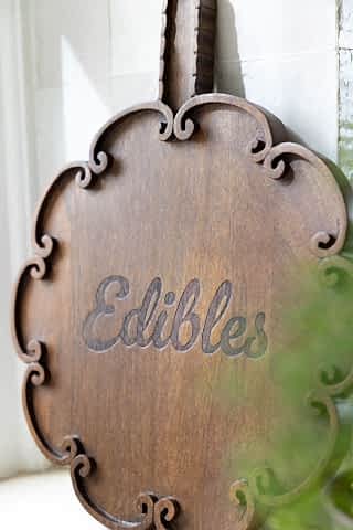 Zoomed in image of he Edibles Scalloped Wooden Serving Board in a kitchen. 
