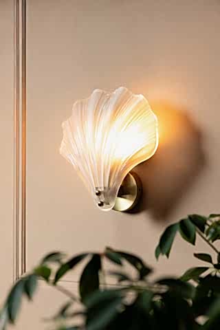Stunning Frosted Glass Shell Wall Light shown against a beige panelled wall with a plant
