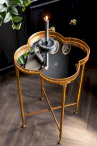 Lucky Clover Mirrored Side Table shown against a black cabinet with a grey candle on the mirrored top. 