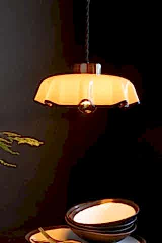 Image of the Monochrome Pleated Glass Easyfit Ceiling Light Shade shown in a kitchen against black walls with the light on. 
