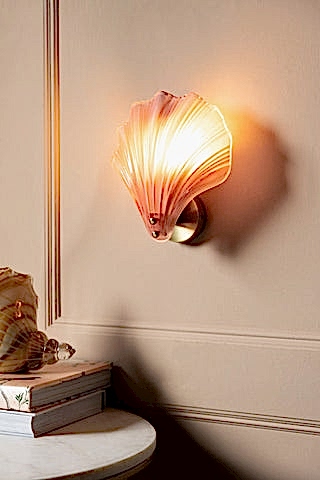 Stunning Pink Glass Shell Wall Light shown with the light on against a beige panelled wall