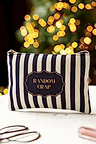 The Random Crap Striped Canvas Pouch shown on a marble surface. 