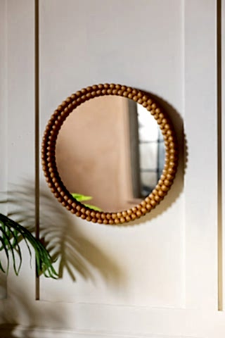Round Bobbin Frame Mirror shown on a panelled wall. 