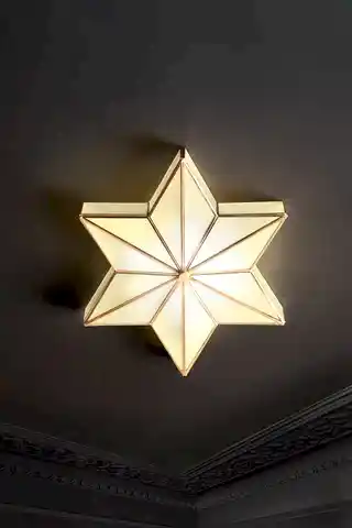 The Star Brass & Glass Flush Ceiling Light shade on a black ceiling and lit. 